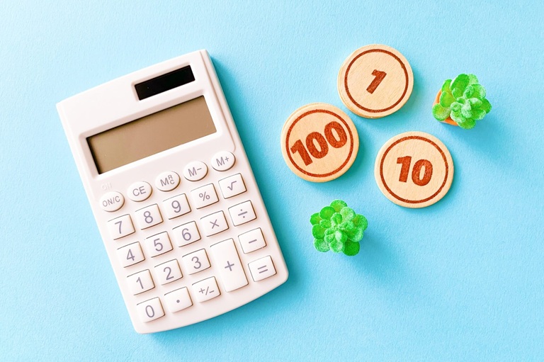 ブルー背景に計算機と木製コイン