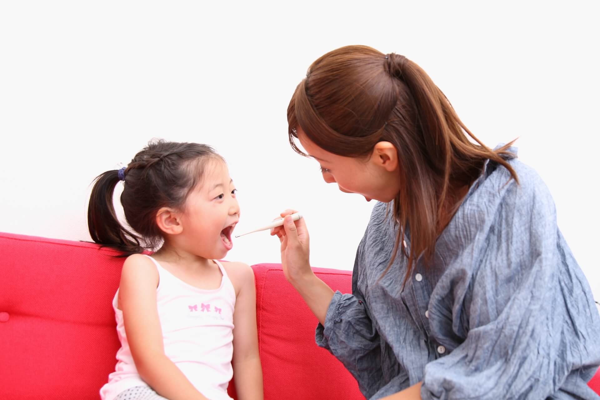 ソファで子供の口を開けて検査