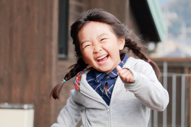 戸外で元気に遊ぶ笑顔の女の子