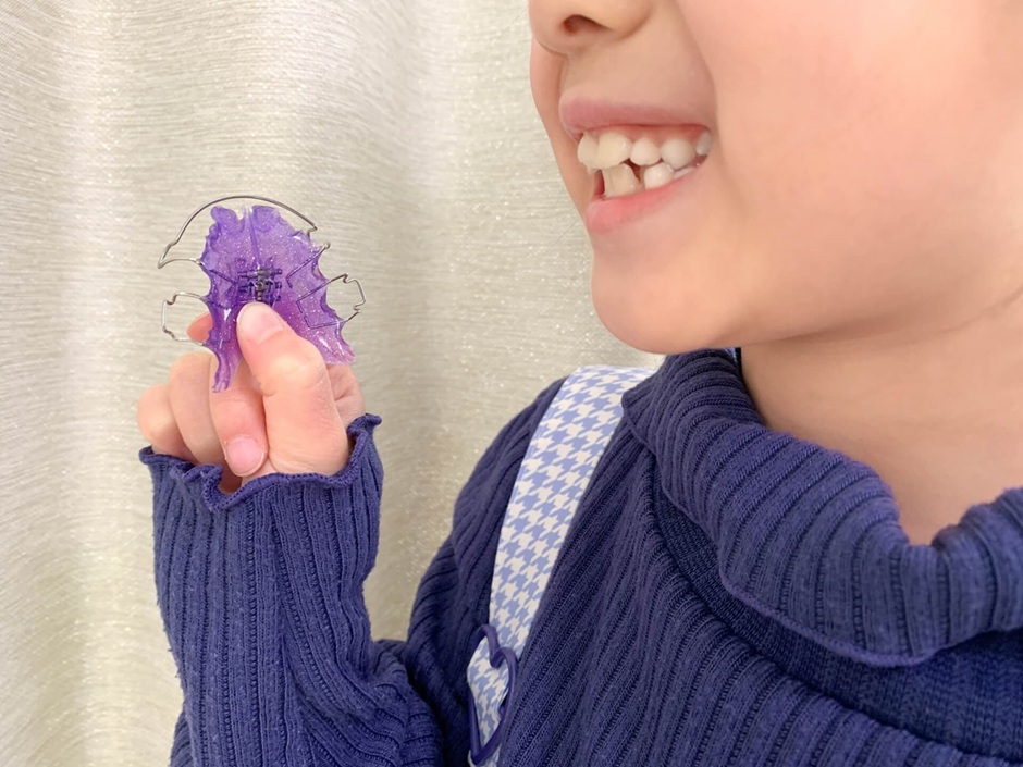 紫色の歯ブラシを持つ笑顔の男の子